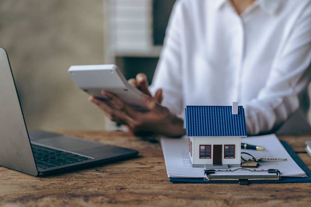 woman calculating property tax due on her home, sitting at a desk
