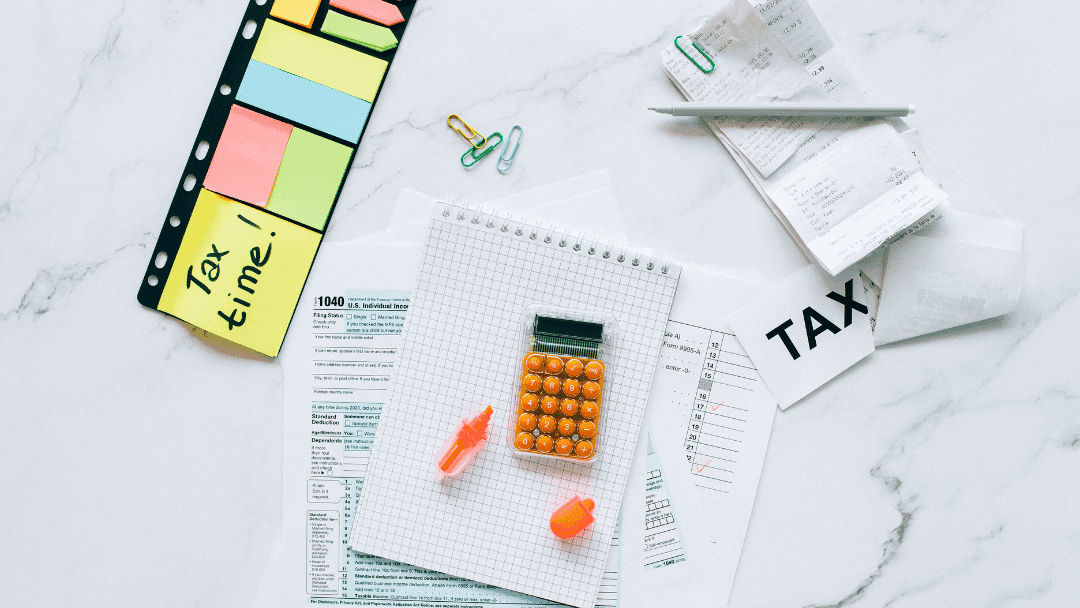 image of tax forms on a table with calculator and sticky notes